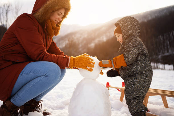 istock Caucasian mother and son, making a snowman 1423307194