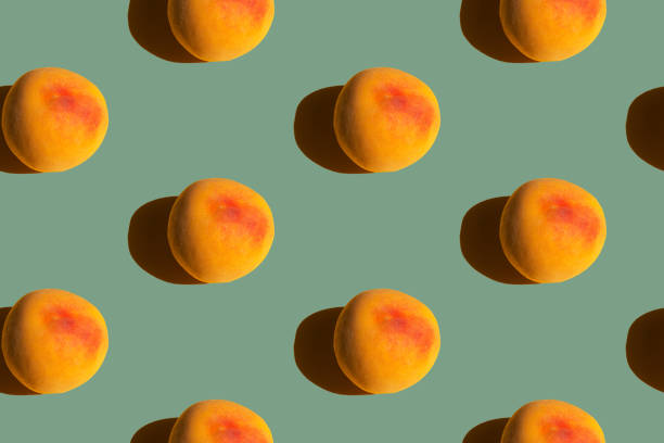 istock Seamless pattern from ripe juicy yellow red peaches on green slate color background. Creative food poster banner template backdrop 1423308513