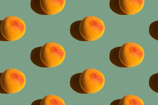 Seamless pattern from ripe juicy yellow red peaches on green slate color background. Creative food poster banner template backdrop for wallpaper product surface design summer theme