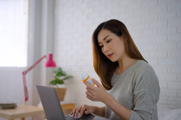 Woman is reading Prescription Medication Label. 