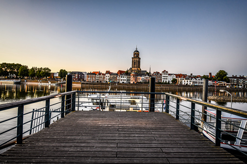 Pier Near Yachts On IJessel River And St. Lebuinus Church On Other Side In Deventer, The Netherlands