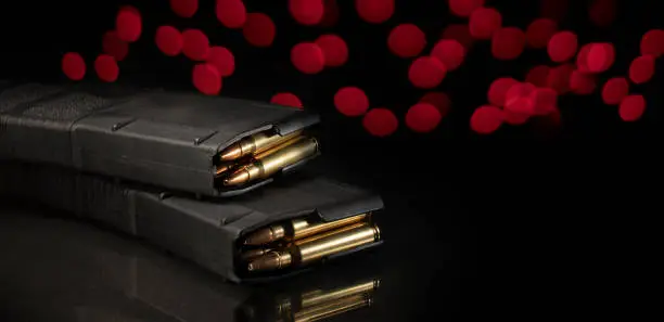 AR-15 magazines loaded with ammo with red lights behind and copy space to the right