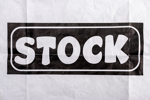 Word stock. Stock photography concept. Folded white paper with the word stock printed on it.