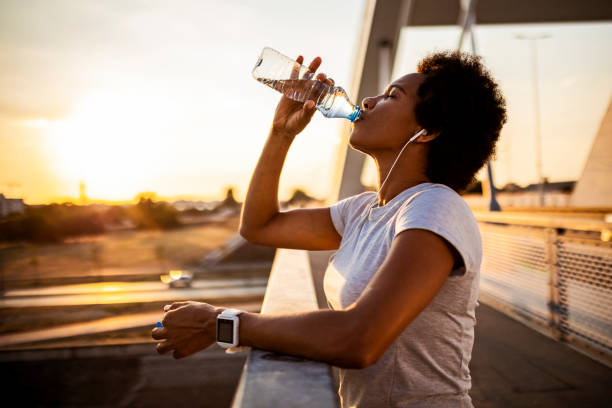 istock Young woman jogger taking a break hydrating 1423311042