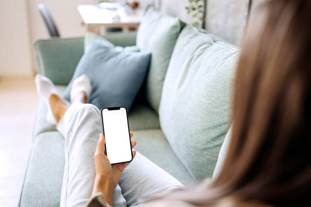 istock Closeup of woman using mobile phone with empty screen at home 1423312898