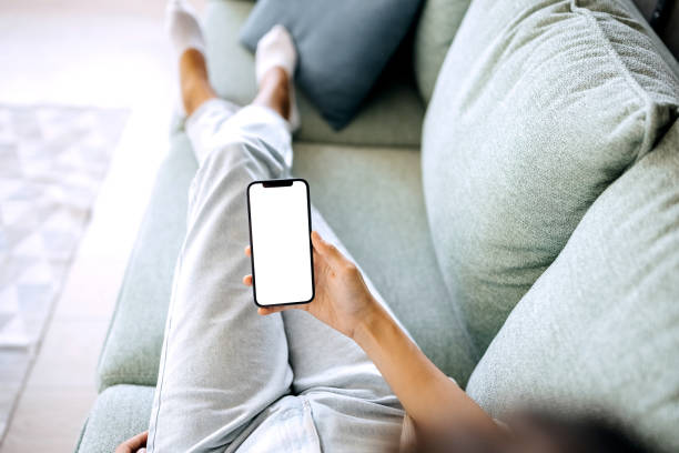 istock Closeup of woman using mobile phone with empty screen at home 1423312899