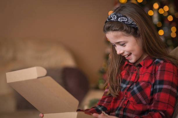istock Happy girl opening a present 1423315041
