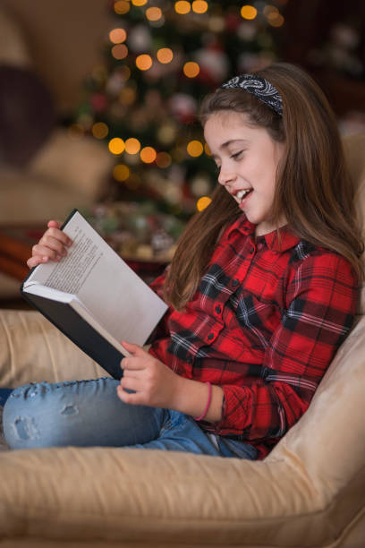 istock Girl holding a book in her hands and looking at it 1423315066