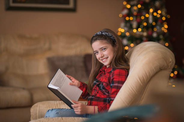 istock Girl sitting at home and holding a book 1423315086
