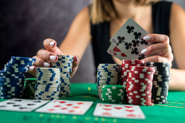 mano femenina tomando fichas de póquer de la pila en la mesa redonda de póker. - gambling fotografías e imágenes de stock