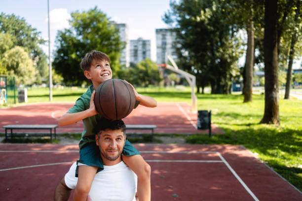 istock Father helps his son to score a basket 1423317365