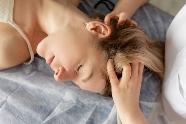 chiudi le mani osteopata massaggiando il collo e la testa del paziente per guarire lo spasmo. assistenza sanitaria manuale, riabilitazione craniosacrale - alternative therapy massaging clinic health spa foto e immagini stock