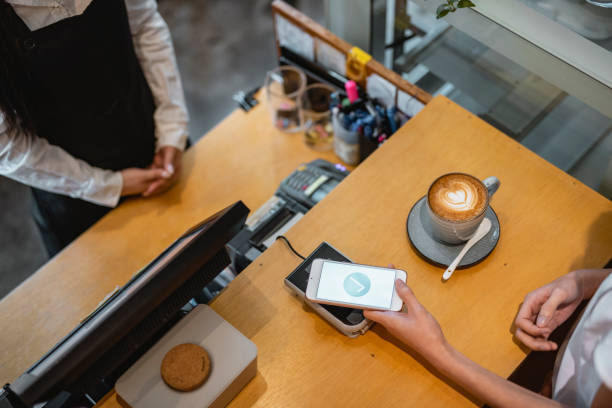 istock High Angle View of Customer Making Mobile Payment for Coffee 1423319172