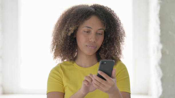 istock African Woman Browing Internet on Smartphone 1423320268