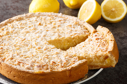Fragrant cake tart with lemon curd and streusel close-up in a plate on the table. Horizontal