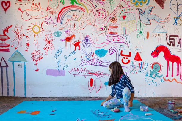 istock Concentrated little girl draws on a canvas 1423322425