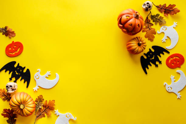 kürbisse mit halloween-dekorationen auf gelbem hintergrund - geist grafiken stock-fotos und bilder