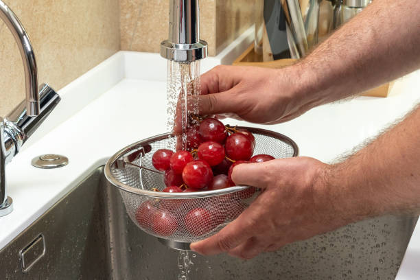 istock Red grapes in a modern kitchen under running water 1423323851