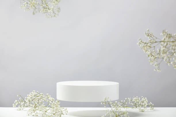 istock Flying empty white podium and white flowers on grey background. Mock up stand for product presentation. 3D Render. Minimal concept. 1423324745