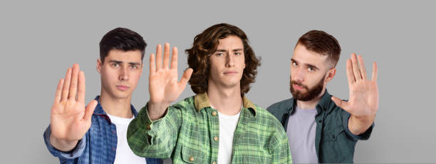 istock Refusal Concept. Group Of Serious Young Men Showing Stop Gesture At Camera 1423325908