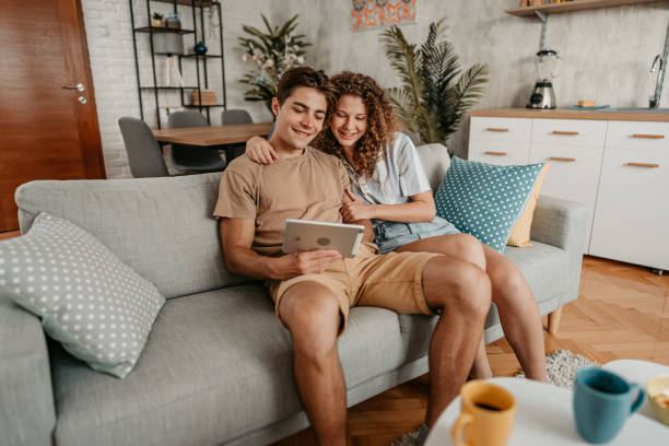 istock Young Couple Sitting On The Sofa And Using Tablet 1423326924