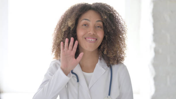 istock Afrcian Doctor Saying Hello by Waving Hand 1423327828