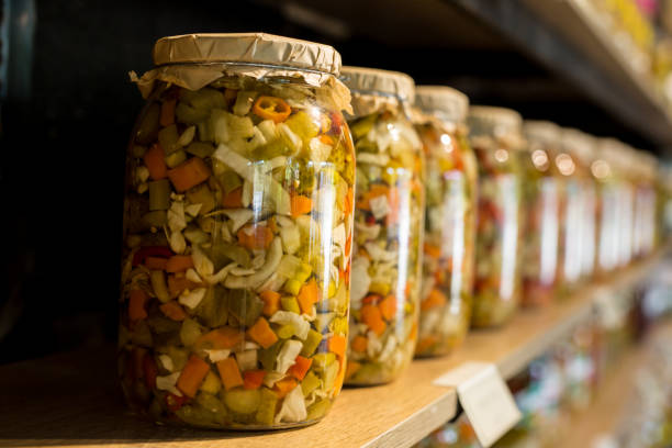 Fermented jars of sliced vegetables in a row on a shelf ready for sale