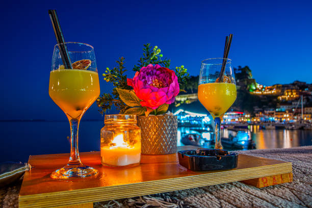 Summer sunset cocktails with Parga city in the background Summer sunset cocktails with Parga city in the background parga greece stock pictures, royalty-free photos & images