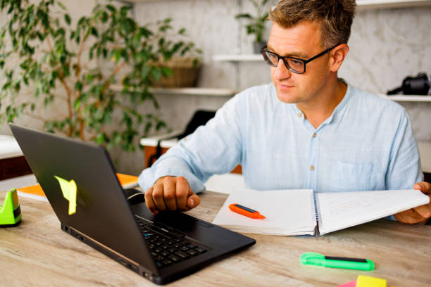 istock Man listening online teacher on laptop while learning online 1423330004