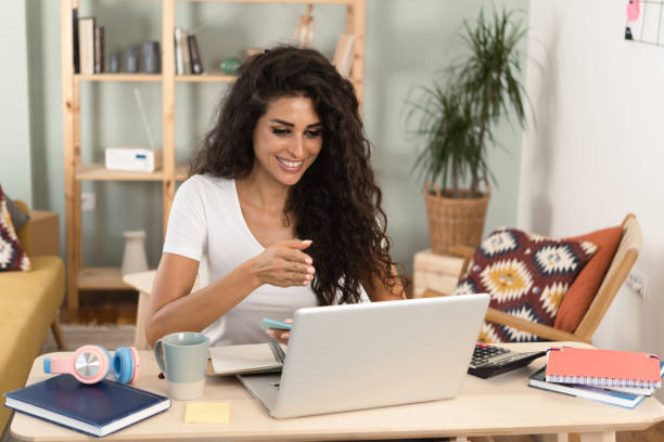 istock Cute young woman working on the laptop 1423330986
