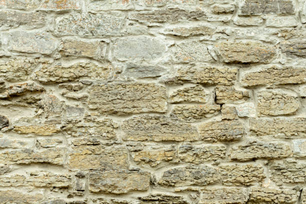 istock Sturdy yellow and beige cut stone wall, good for backgrounds 1423332201