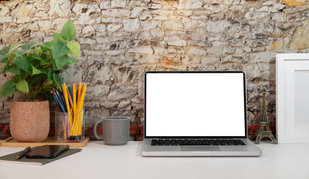istock Computer laptop with empty screen, coffee cup, and potted plant on table. Home office. 1423332749