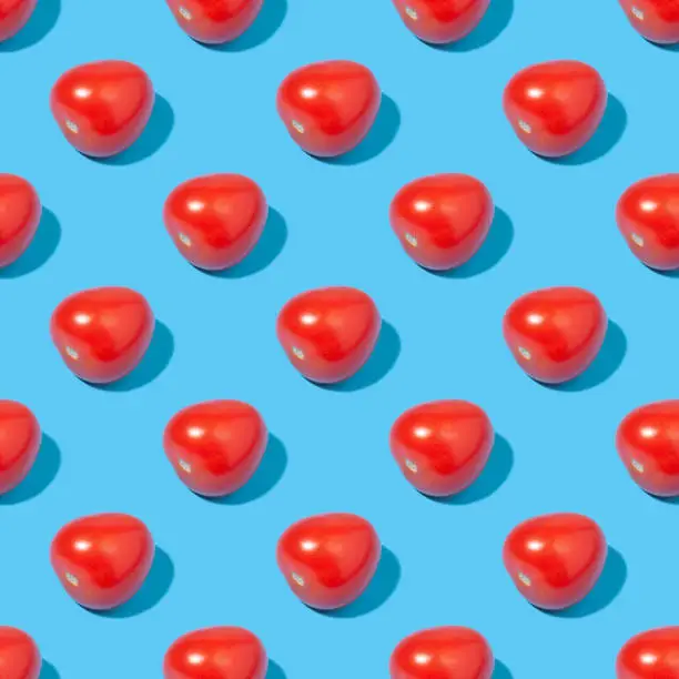 Seamless background with tomatoes - absolutely seamless pattern with red tomatoes on a blue background