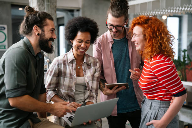istock Diverse group of professionals meeting in office. IT programmers use computer, talk strategy 1423335674