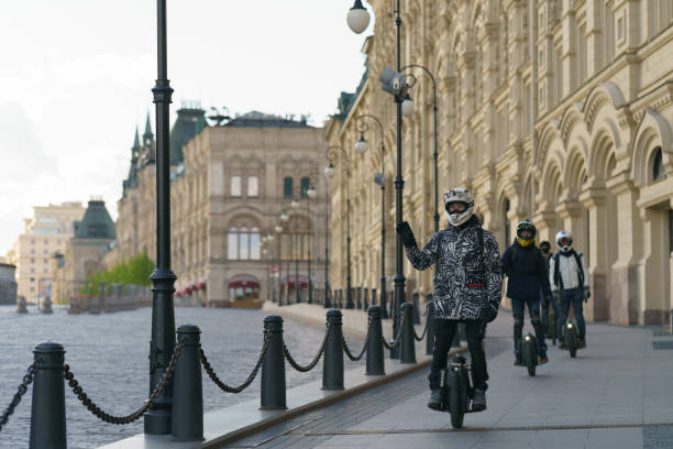 team of young men driving electric unicycle in the moscow city center. - unicycle men young adult standing imagens e fotografias de stock