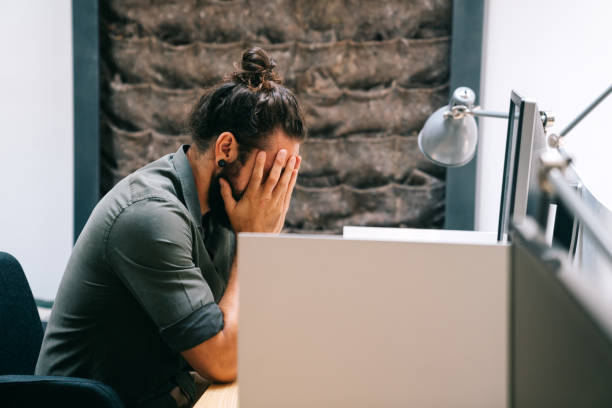 istock Tired exhausted man, office worker, manager or freelancer, working in office 1423336330