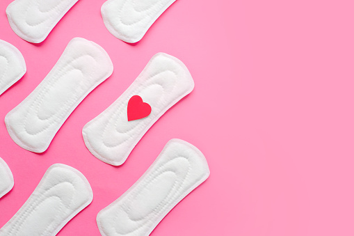 Almohadillas menstruales femeninas sobre fondo rosa, salud de la mujer, concepto de ciclo de períodos de la mujer, espacio de copia photo