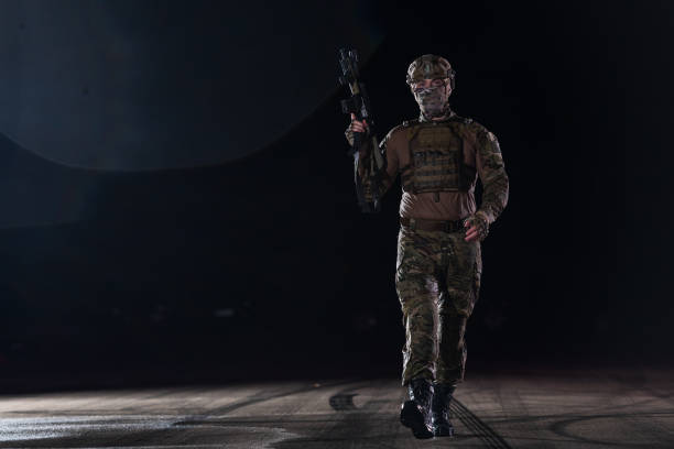 armeesoldaten in kampfuniformen mit sturmgewehr, plattenträger und kampfhelm auf eine gefährliche mission in einer regnerischen nacht. - real people caucasian one person black and white stock-fotos und bilder