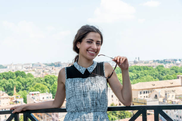 istock Young woman looking at the camera, in back skyline Rome 1423339431