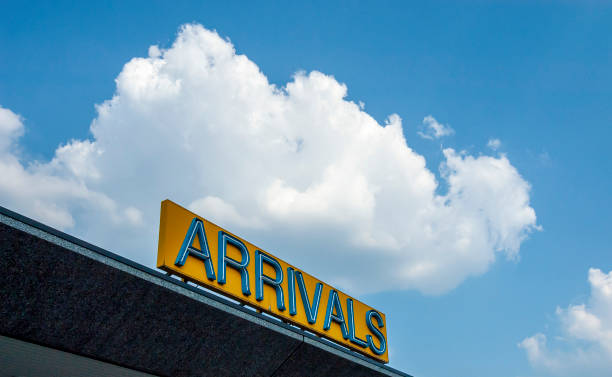 low angle view on departure sign  at a blue sky with some clouds