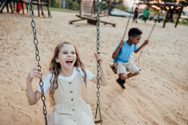 istock Children playing on the playground swinging 1423340131