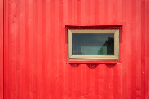 A mobile metal container office cabin with glass window at construction working site. Industrial building equipment photo.