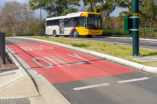 Adelaide, Australia - August 10, 2019: Adelaide Metro bus is travelling to the city from the Salisbury Interchange. O-Bahn Busway is a guided busway that is part of the bus rapid transit system servicing the northeastern suburbs of Adelaide