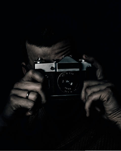 istock The guy is holding an old camera in his hands. Vintage camera 1423344557