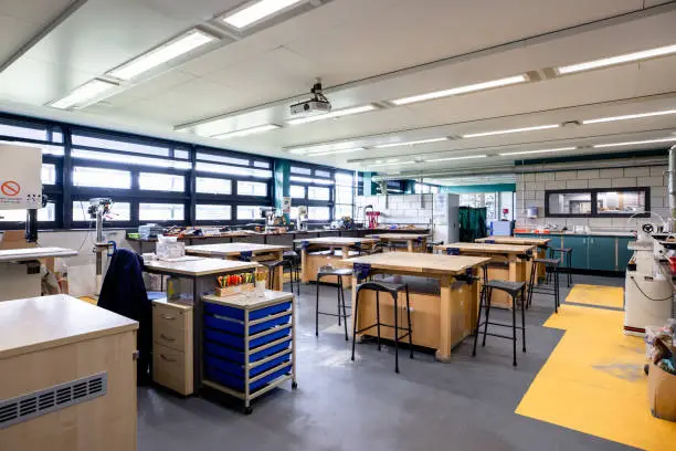 A woodshop classroom filled with workbenches and chairs in a secondary school in the North East of England.