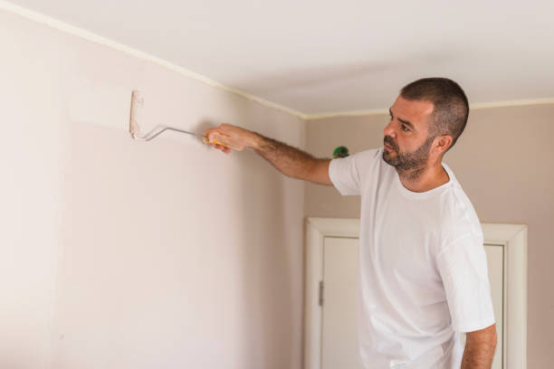 istock Man using painting roller when painting walls 1423348013