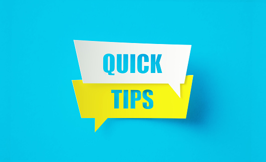 Quick tips written cut out yellow and white speech bubbles sitting on blue background. Horizontal composition with copy space.