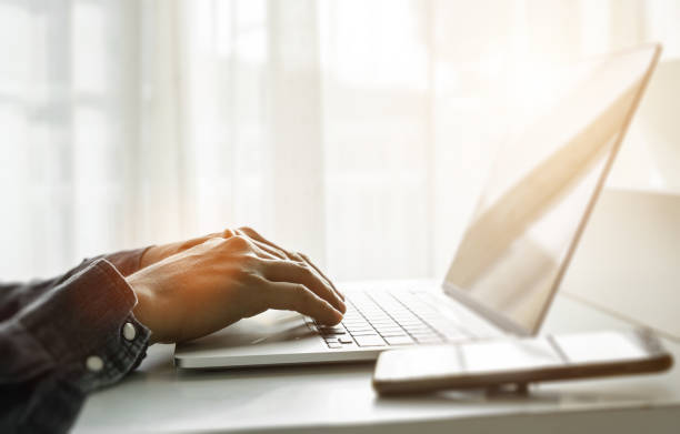 istock Close up of man hands using laptop at home office. Concept of searching web, browsing information. soft focus 1423348546