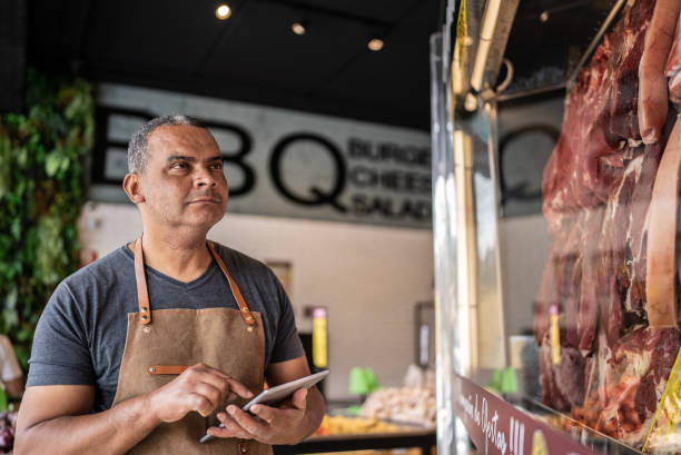 propietario de un negocio con tableta digital haciendo inventario en una carnicería - red meat fotografías e imágenes de stock