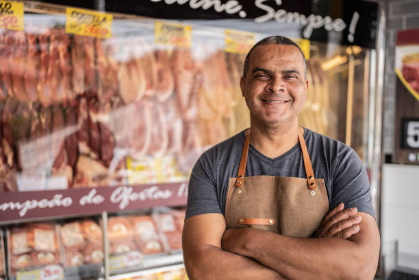 portrait of a butcher's shop owner - supermarket meat store manager imagens e fotografias de stock